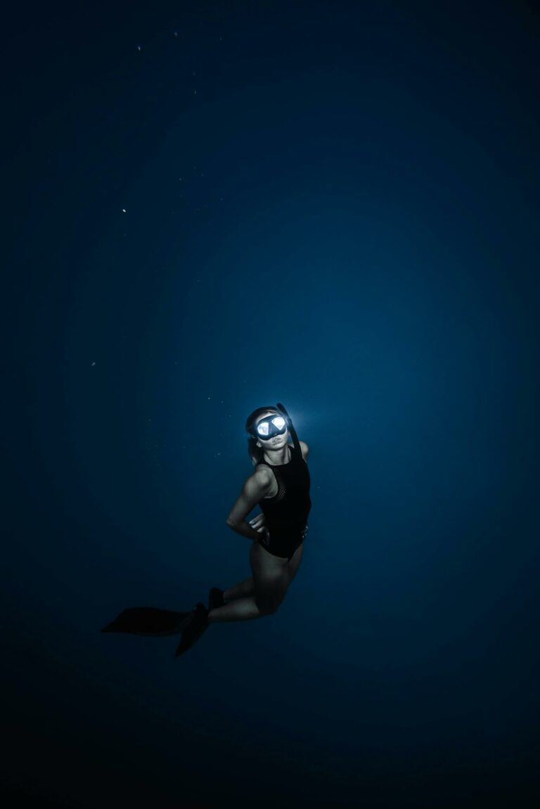 Unrecognizable woman diving in blue sea water