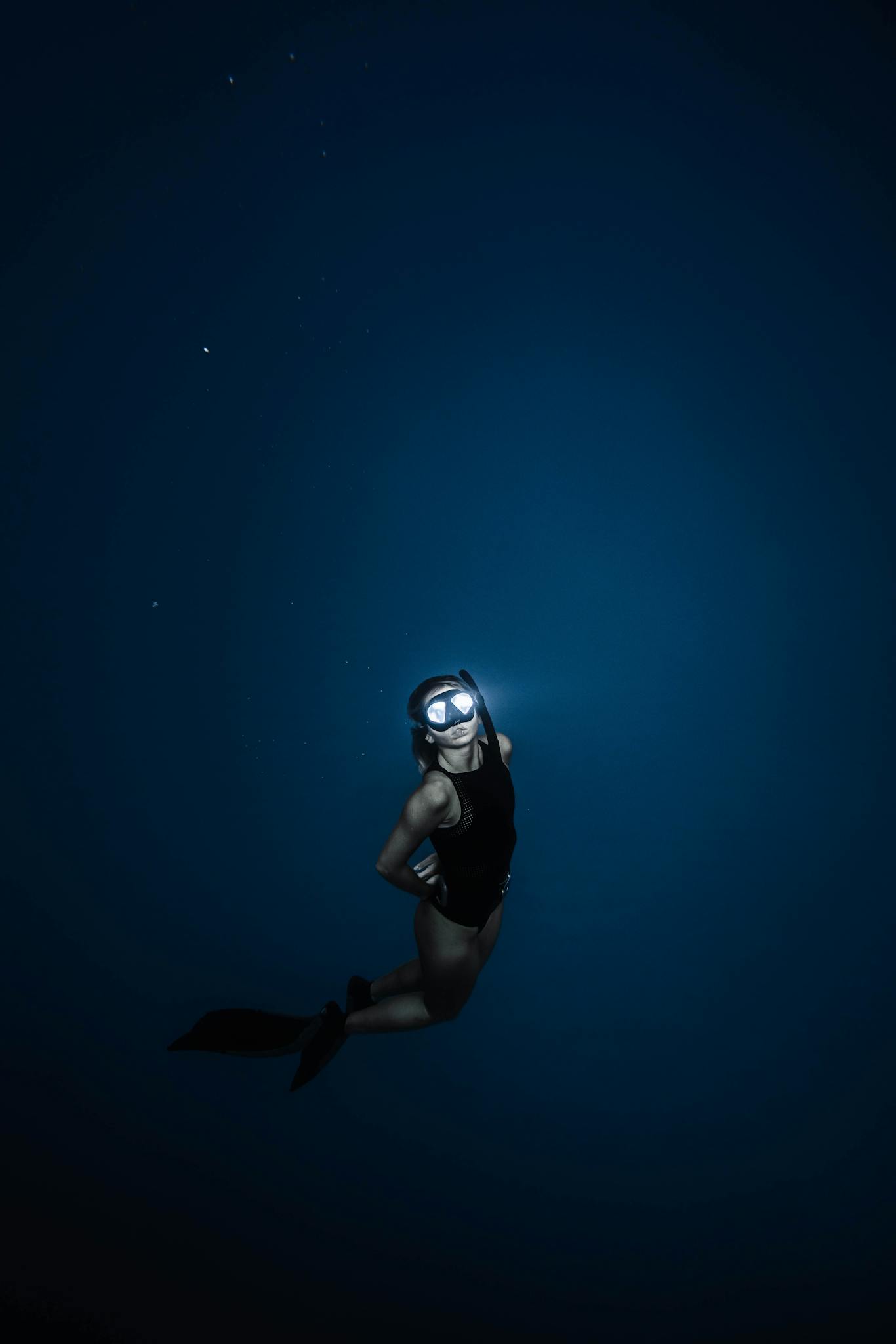 Unrecognizable woman diving in blue sea water